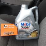 Пластиковая канистра с маслом Mobil Super 5W-40 на водительском сидении в Лада Калина